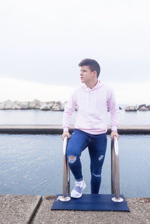 Young male teenager standing on pier