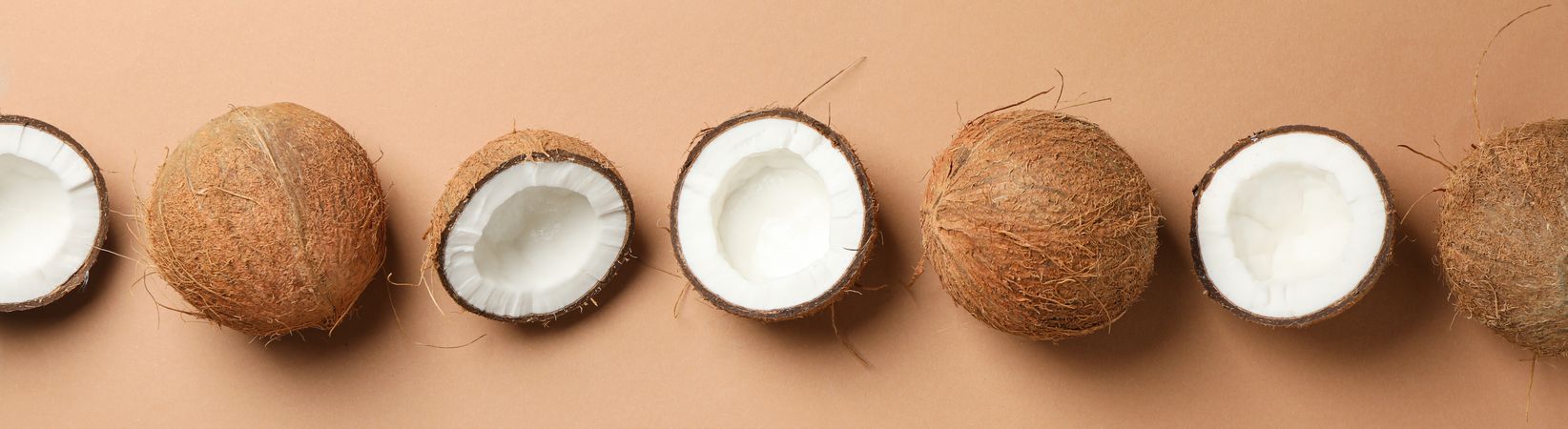 Flat lay with coconut on brown background, space for text