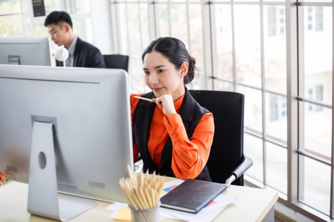 Female creative thinking at desk in the office