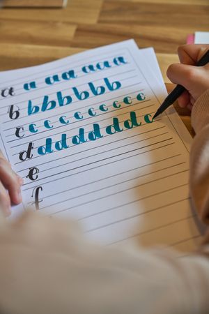 Crop unrecognizable person drawing letters