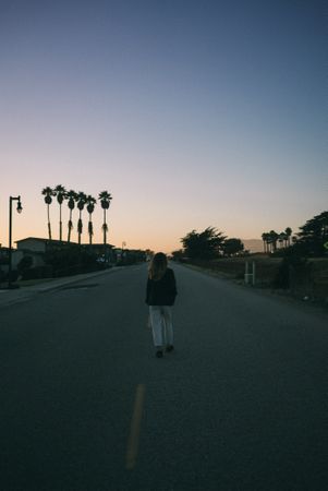 Back of woman walking down street in California, vertical