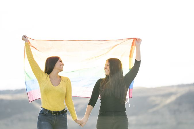 Young women couple with rainbow flag