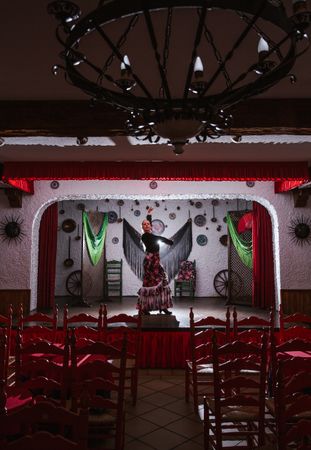 Woman dancer in flamenco costume standing in dance posture