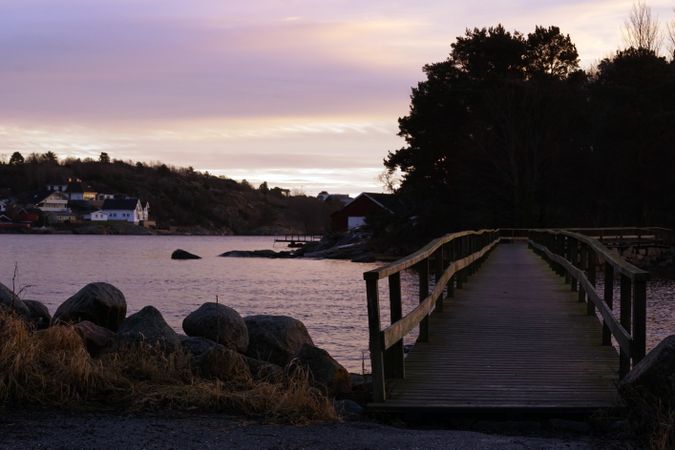Scenic town on seaside in twilight with wooden bridge