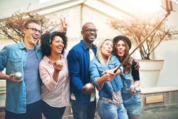 Multi-ethnic group of friends taking a funny picture of themselves outside