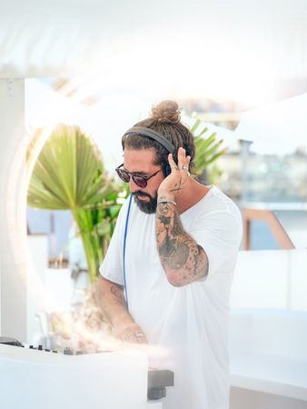 Disc jockey in headphones playing music on terrace