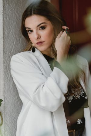 Stylish woman standing near red door