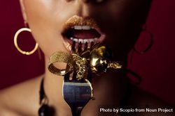 Woman eating golden jewelry bE7Go5