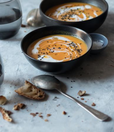 Bowls with pumpkin cream soup on table
