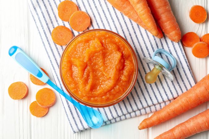 Composition with carrot puree on wooden background. Baby food