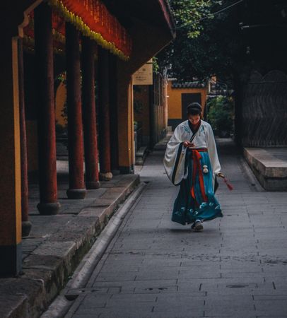 Chinese woman in traditional outfit walking beside temple during daytime in China
