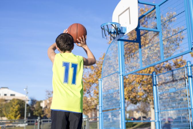 Basketball, teen shooting into basket in outdoor park