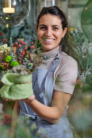 Young female florist with flower bouquet in box