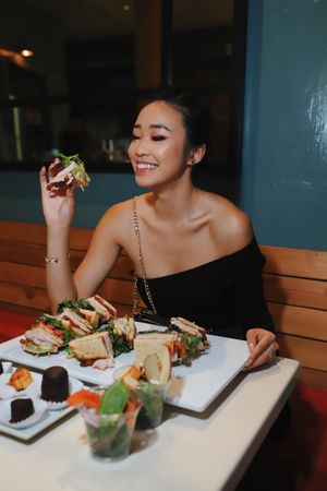 Woman about to eat club sandwich at a restaurant