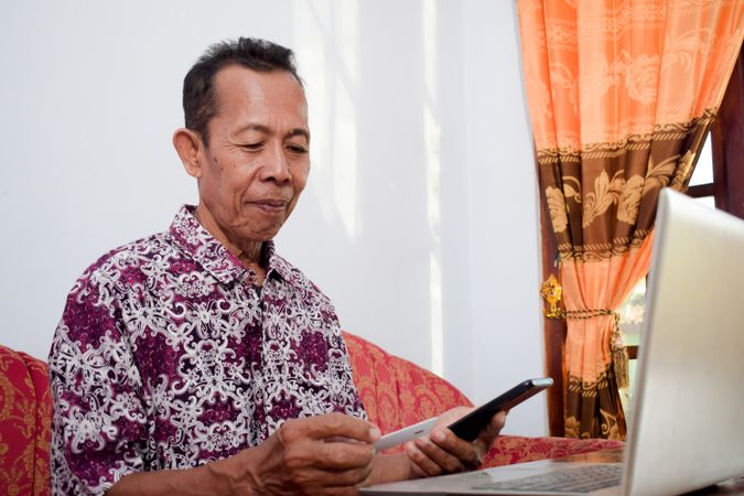 Man holds and looks at the blank credit card doing payment online