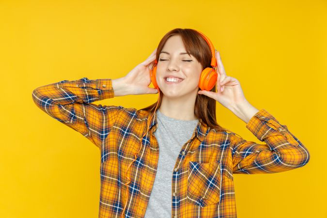 Concept of people, woman with headphones on yellow background