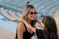 Little girl helps mom to put on sunglasses on walk