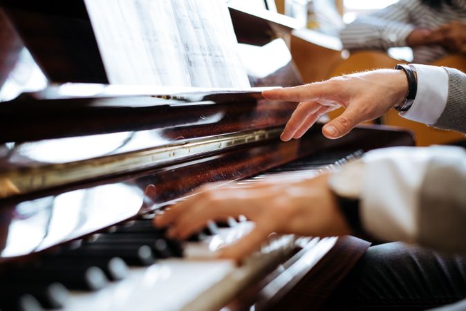 Crop male hands playing piano