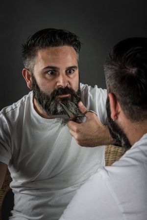 Expressive barber cutting beard
