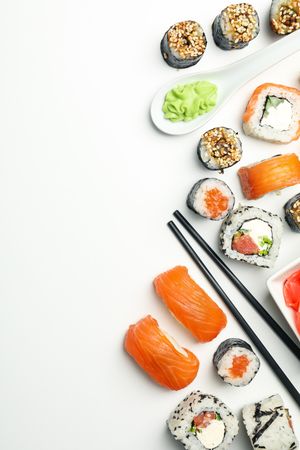 Sushi rolls and chopsticks on light background, space for text. Japanese food