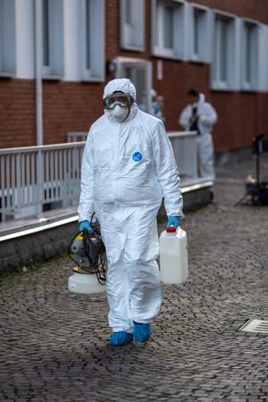 Man in PPE holding sanitizing machine