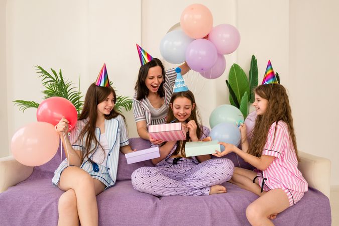 Laughing family opening presents at birthday party at home.