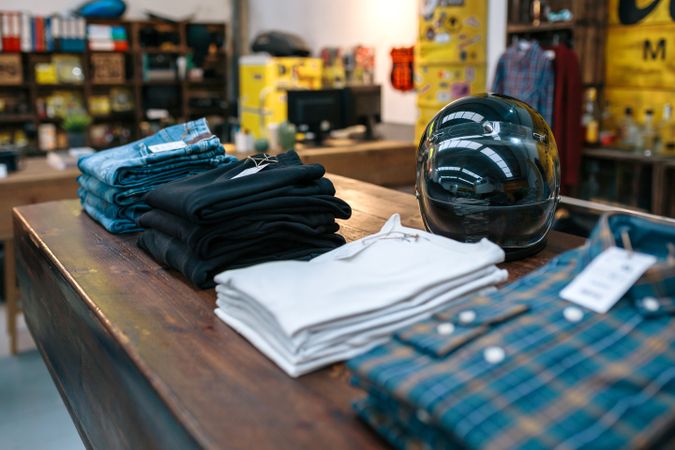 motorbike helmet and new clothes collection over counter on vintage store