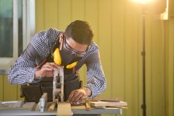 Carpenter cutting a piece of wood