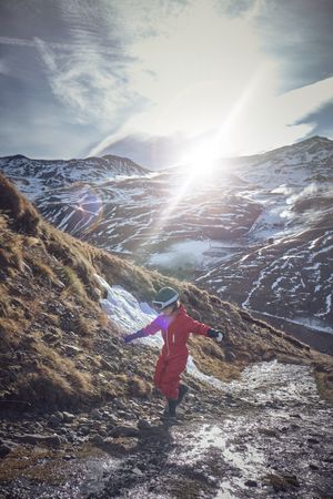 Kid balancing on stones in mountains