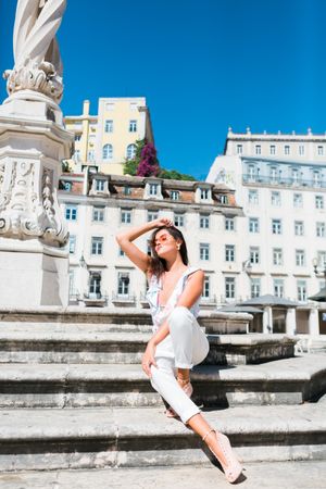 stylish woman in sunglasses sitting in street stairs