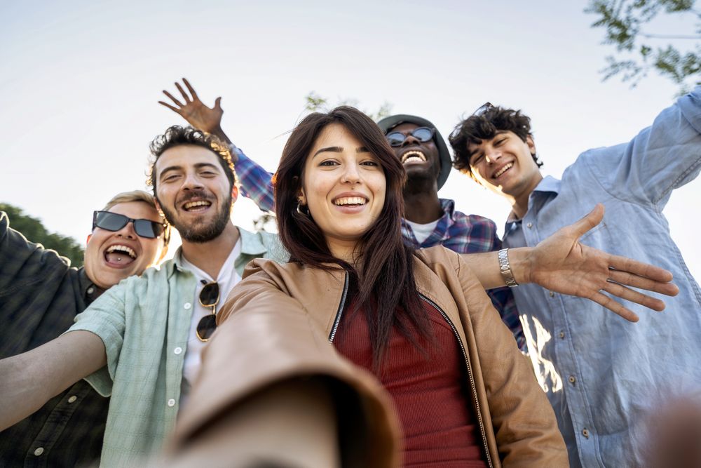 Diverse Gen-Z friends taking joyful selfie on summer day trip