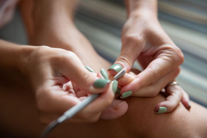 Woman Doing Pedicure at Home Removing Cuticles