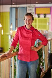 Cheerful female cook in modern apartment