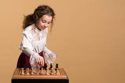 Young girl concentrating while moving chess piece