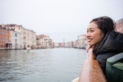Asian female on vacation on ferryboat on waterline at city