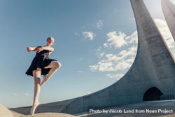 Female dancer balancing on one toe in pointe shoes on a rock 5Qo2gb