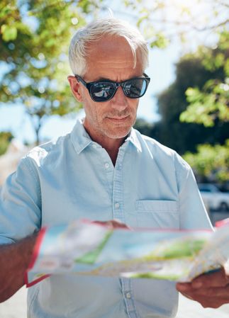 Male tourist looking at city map