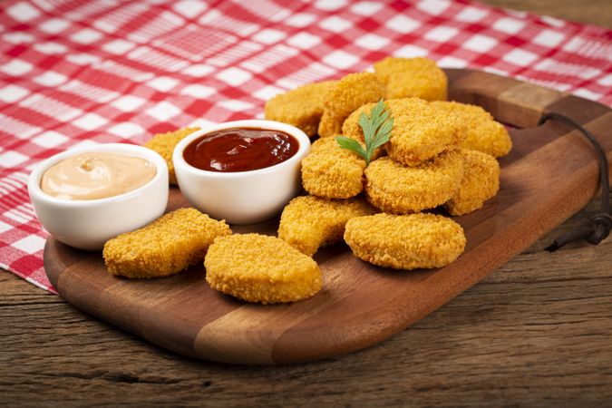 Fried chicken nuggets with ketchp and rose sauce.