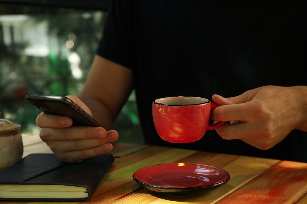Man using phone and drink coffee in restaurant