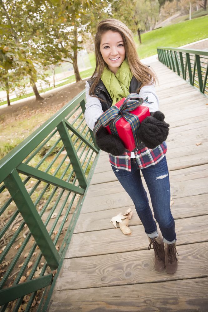 Woman Walking with Wrapped Gift with Bow Outside
