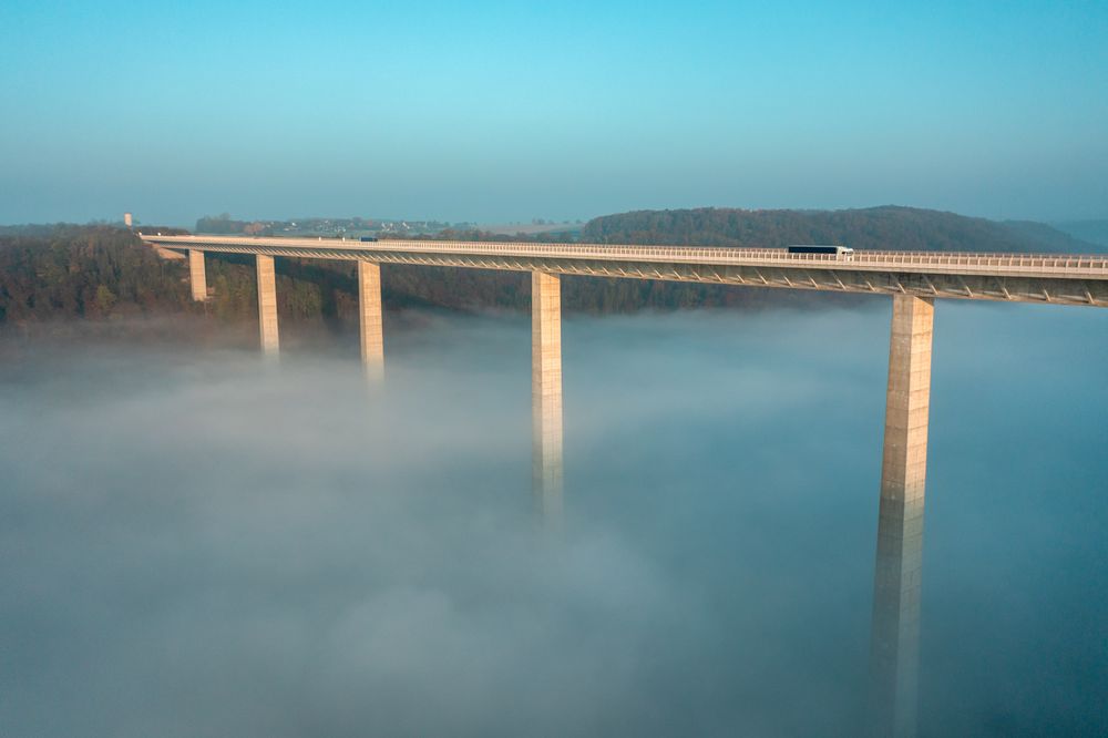 Majestic highway bridge in a foggy scenery, drone aerial view in Germany