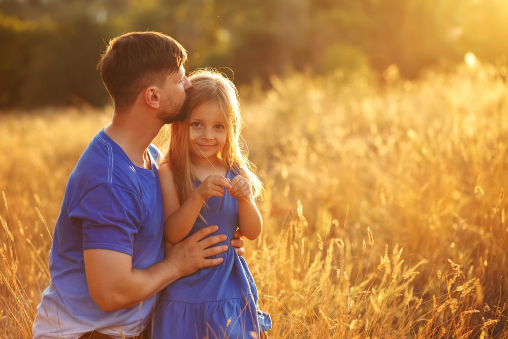 Dad and daughter child playing in field of long grass