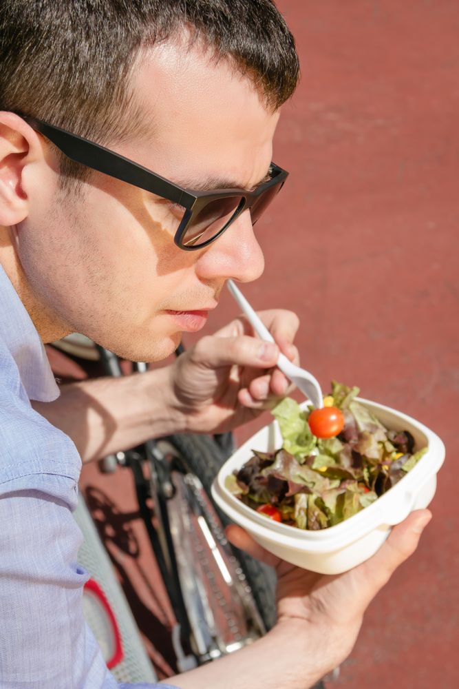 Young business man eating at lunch break outdoors