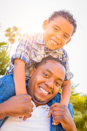 Son and Father Playing Piggyback Outdoors Together.