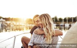 Couple embracing on a boat at sunset 0LnoV4