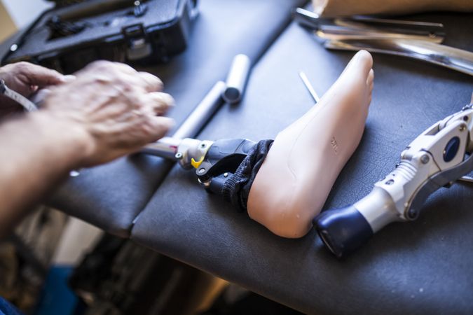 crop man fixing prosthesis in workshop
