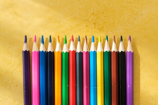 Coloured pencils for drawing on a yellow background