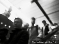 Blurry photo of men on escalator in grayscale bGgpXb