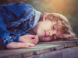 Boy lying on boardwalk and looking at camera
