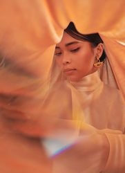 Woman in Art Deco earrings with orange fabric draped over her head